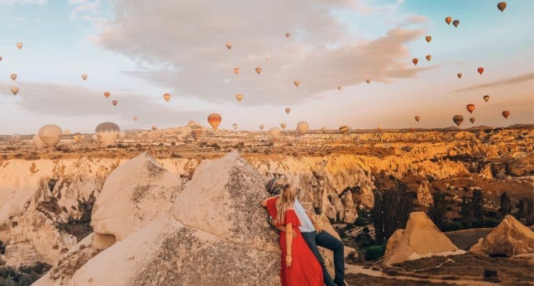 Couple looking at the Hot air Balloons over the Red Valley in Cappadocia, Turkey