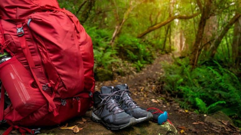 Backpacker hiking checklist essentials - red backpack hiking shoes on hiking trail
