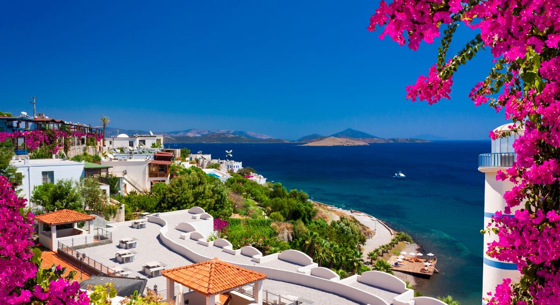 Picturesque Ortakent Beach, Bodrum, Panoramic Bay with hotels and villas overlooking the Mediterranean.