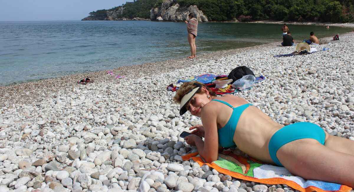 Sun lovers on the white Pebbled Turkey Cirali Beach